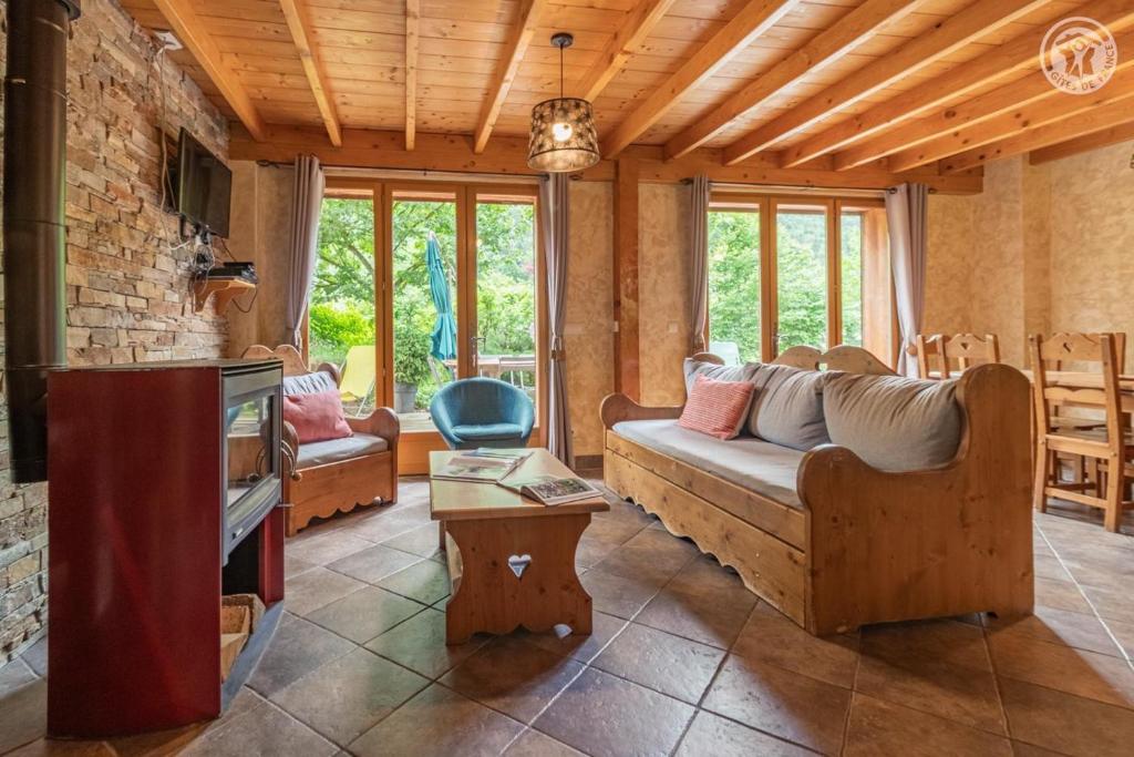 a living room with a couch and a tv at Gites le moulin - lanchette in La Compôte