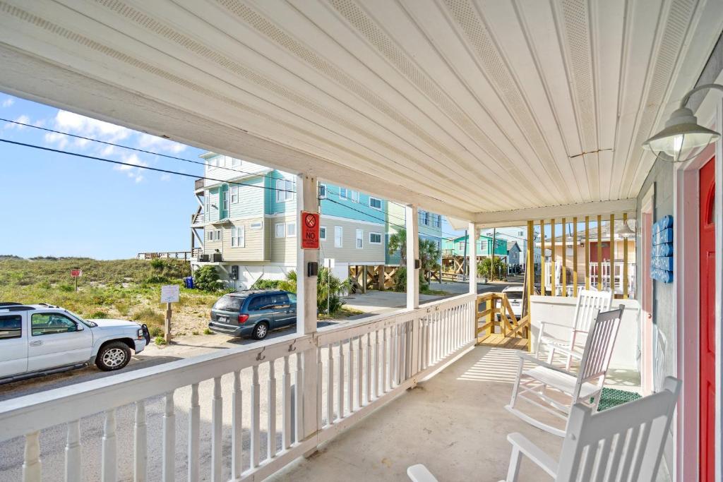 a porch of a house with a chair and a car at Vitamin Sea Suites 4 in Carolina Beach