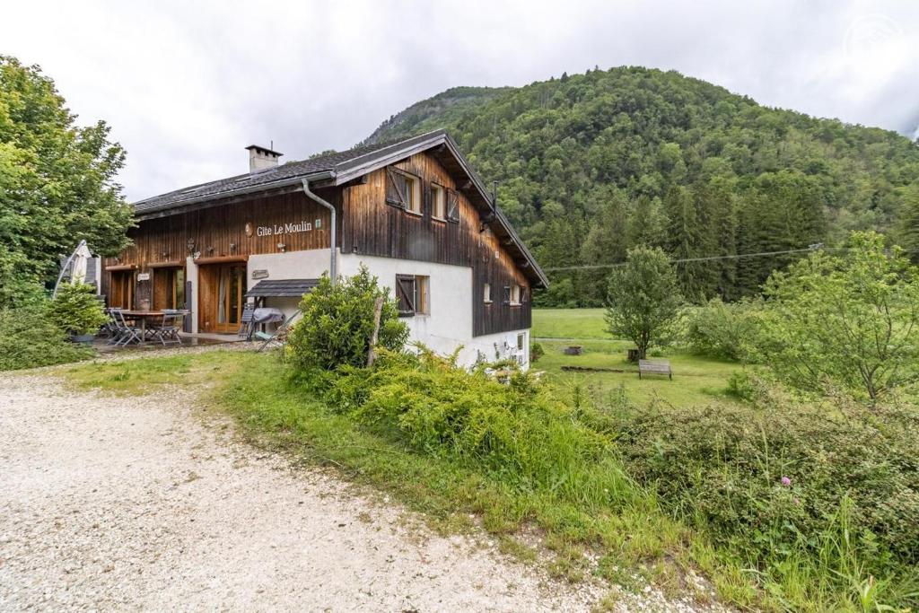 an old barn with a mountain in the background at Gites le moulin in La Compôte