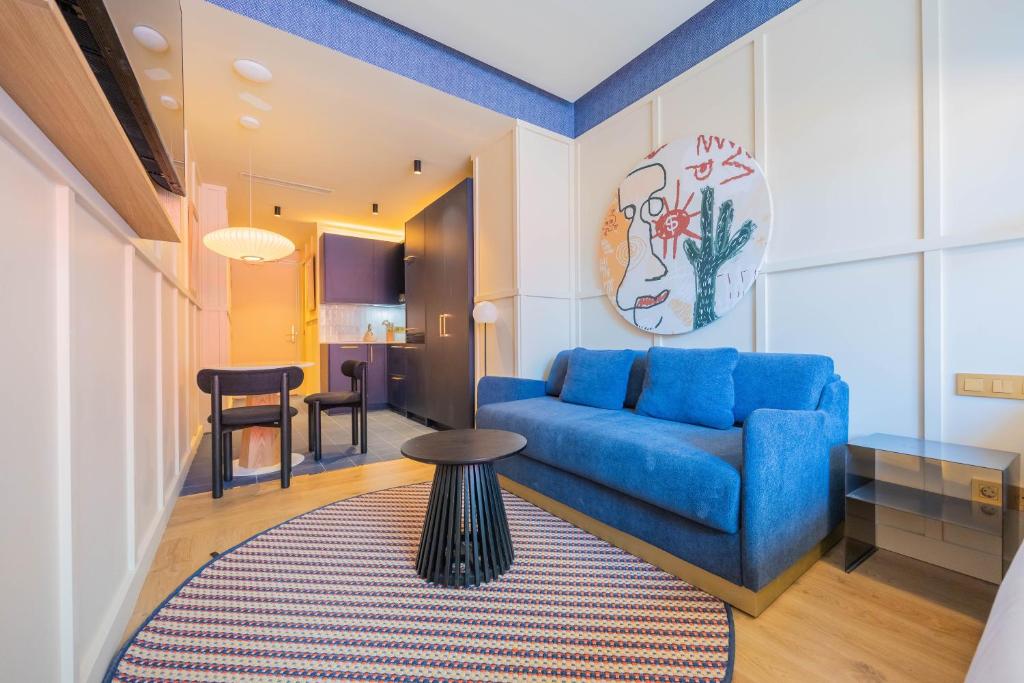 a living room with a blue couch and a table at CP Apartments San Mamés in Bilbao