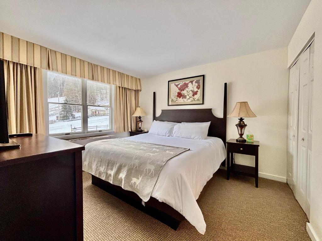 a bedroom with a large bed and a large window at Ski in-out, Slope and Pool Views 1BR at Country Inn in Hancock