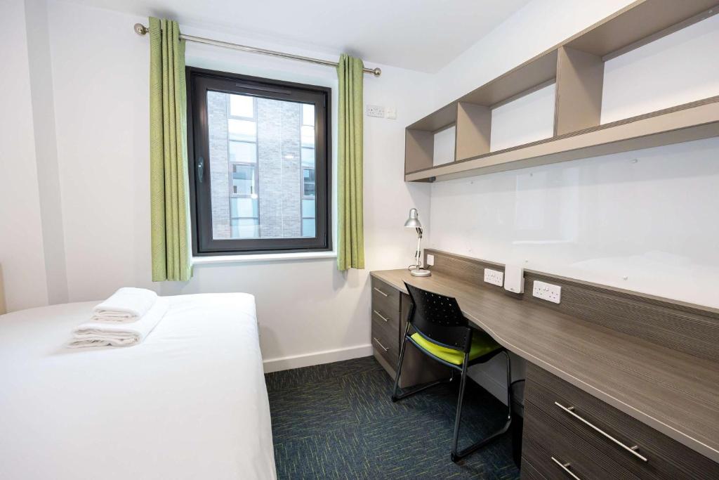 a room with a bed and a desk and a window at Single Ensuite Rooms In Central Preston in Preston