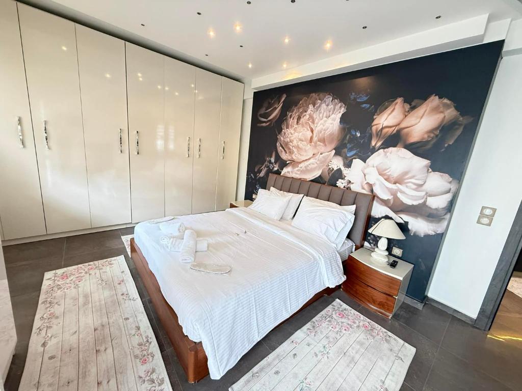 a bedroom with a large bed with a painting on the wall at Tropical Apartment Hanioti in Hanioti