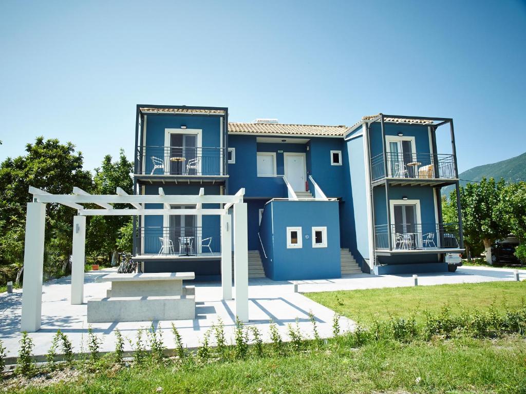 una casa azul con un cenador frente a ella en Cosmos Apartments, en Vasiliki