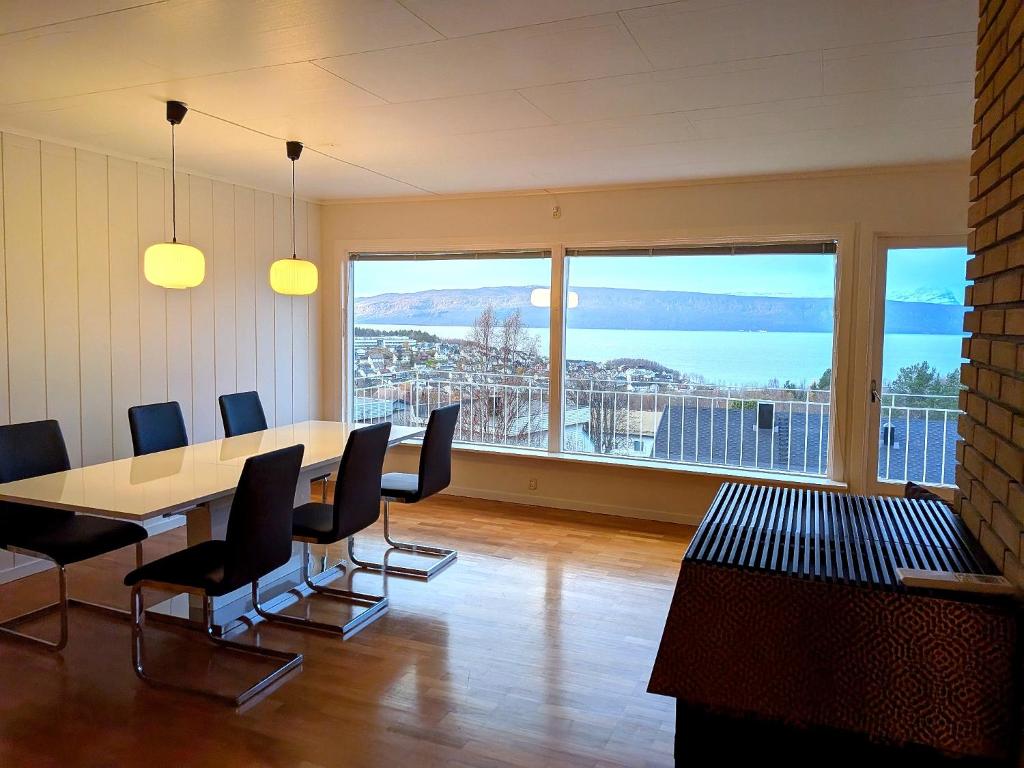 ein Konferenzraum mit Tisch und Stühlen und einem großen Fenster in der Unterkunft Aurora Fjord View Escape Narvik garden sleeps 10 in Narvik