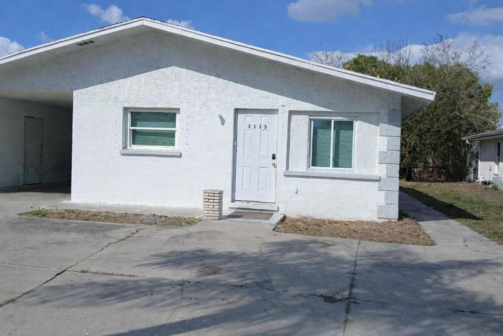 a white house with a door in a driveway at GpL 3115 A Family Get Away in Fort Myers