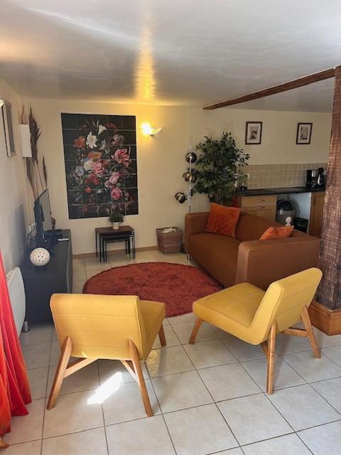 a living room with a couch and a table at Le Plantier 1 in Beaulieu-sur-Sonnette