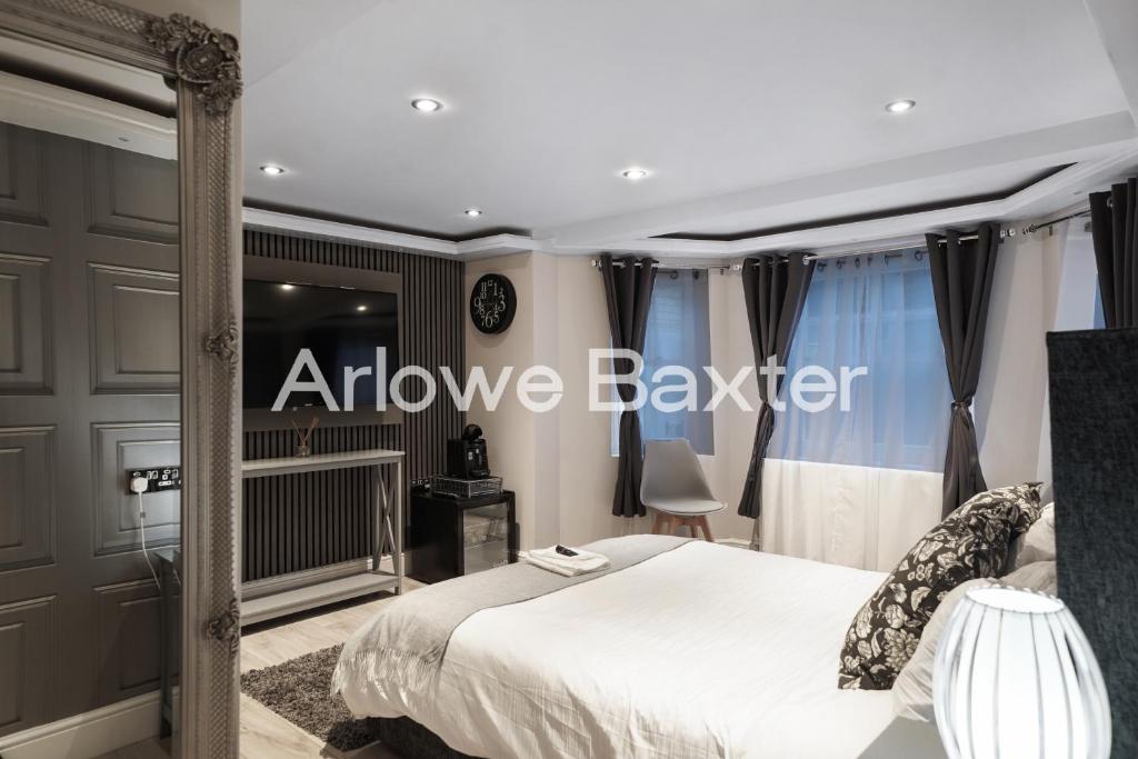 a bedroom with a bed and a window with the words approve baker at Hackney Suites - En-suite rooms & amenities in London