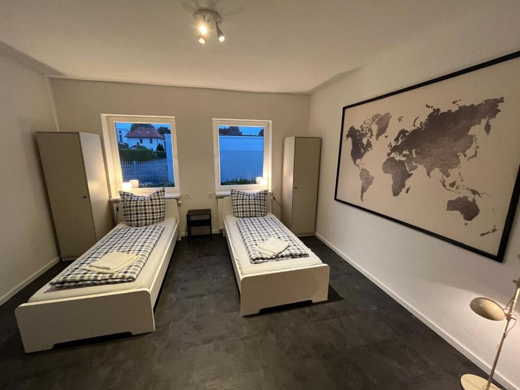 two beds in a room with a map on the wall at Work & Stay - Monteurzimmer - FeWo am NOK in Rendsburg
