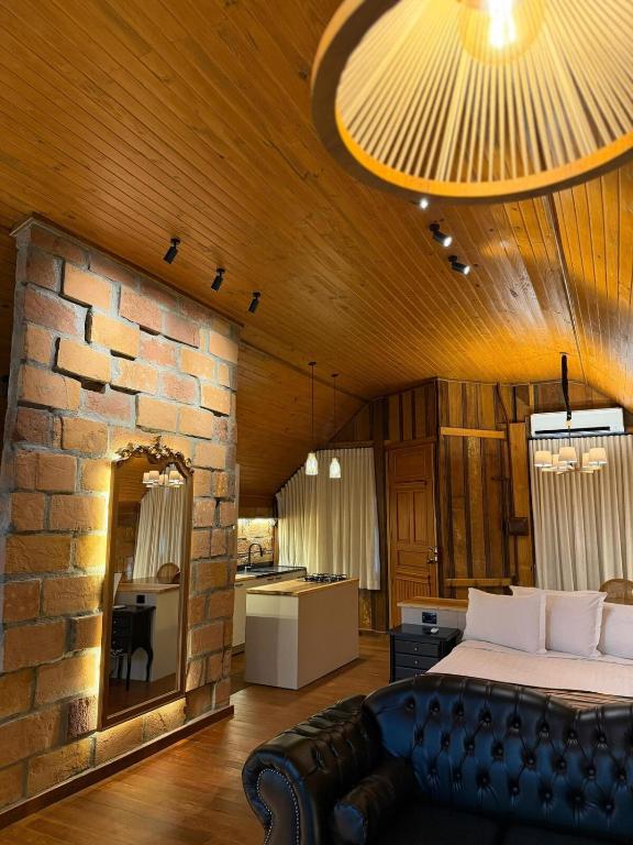 a bedroom with a bed and a stone wall at Chalé Belluno in Casca