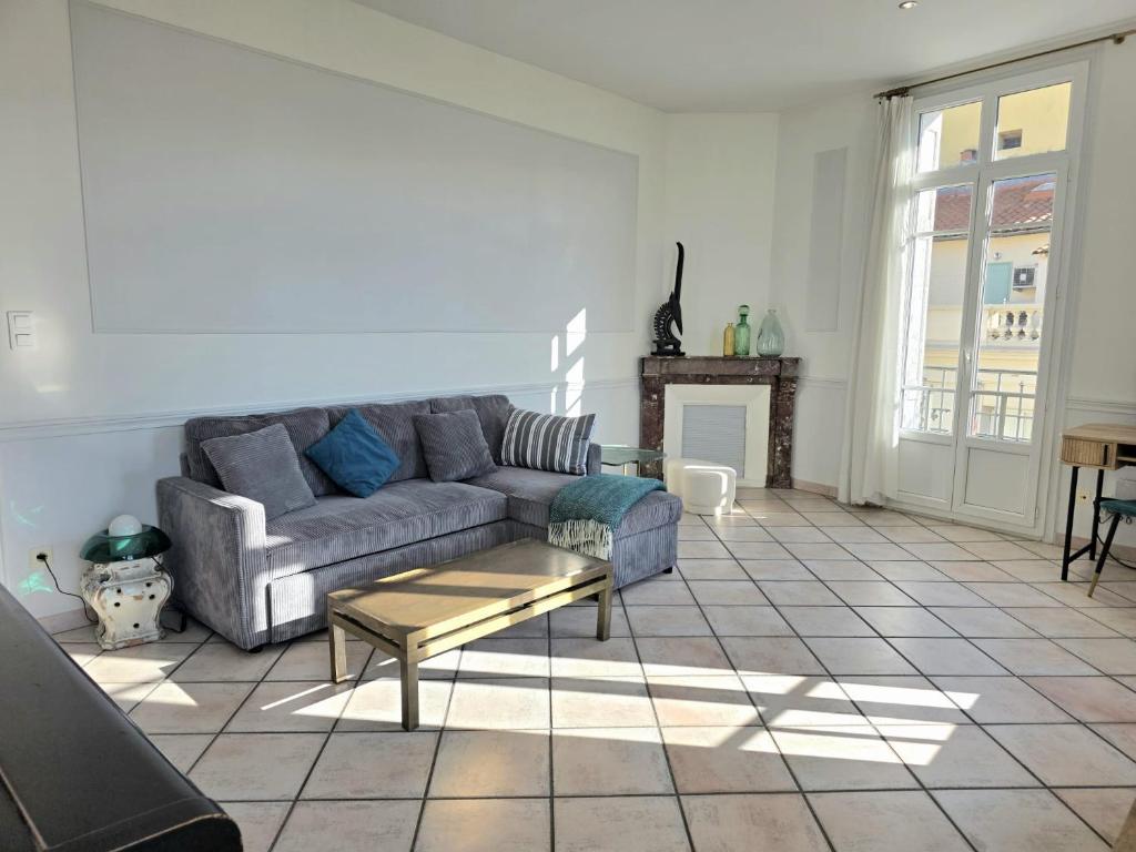 a living room with a couch and a table at L'Authentique Centre-Ville - Perpignan in Perpignan