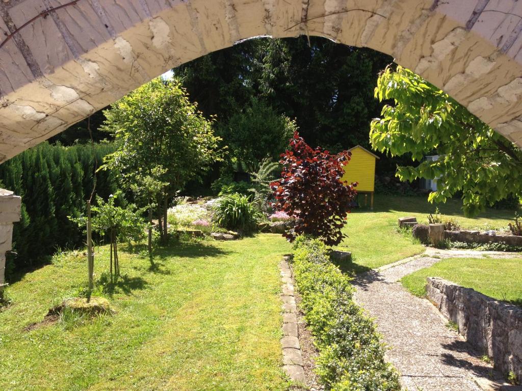 einen Torbogen über einem Garten mit Bäumen und Sträuchern in der Unterkunft Ferienwohnung Baars in Bad Sachsa