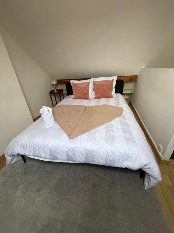 a bedroom with a large white bed with two pillows at Homewood - entire property for 6 people - 4 adults maximum - in village 10 min from Disneyland Paris & TGV RER A in Montry