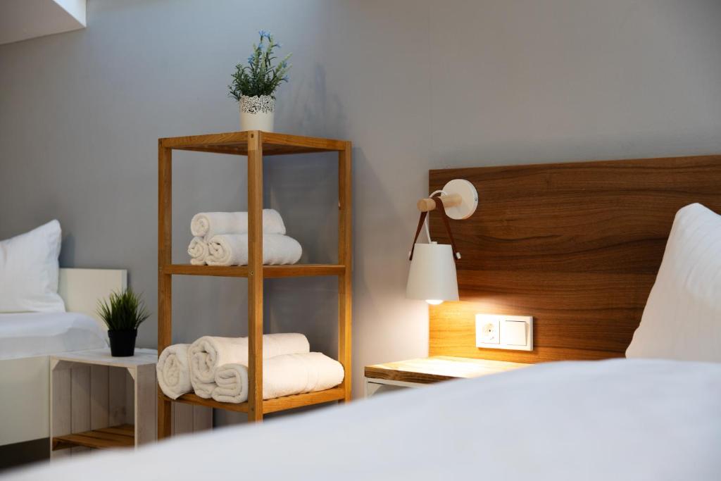 a room with a bed and a shelf with towels at JUNIPRO Apartments Bostalsee in Bosen-Eckelhausen