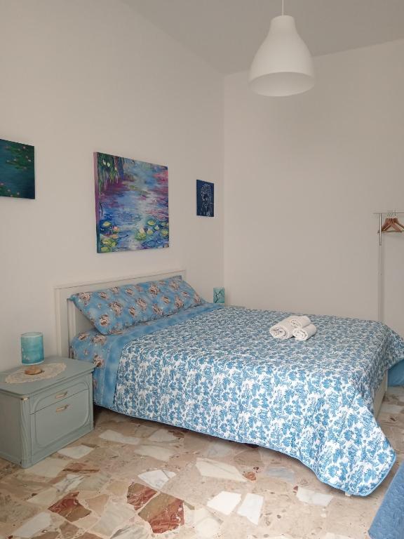 a bedroom with a bed with a blue comforter at Maison d'Artiste Siracusa Belvedere in Belvedere