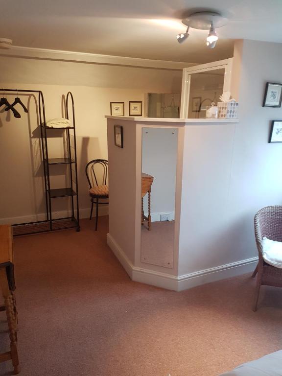 a living room with a table and a mirror at Lammas Park House in Dawlish