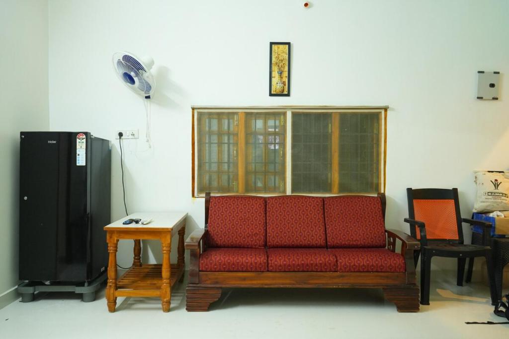 a living room with a red couch and a table at Green Heavan Farm in Sadras