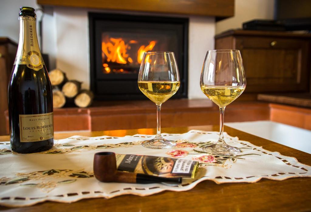 2 Gläser Wein auf einem Tisch mit Kamin in der Unterkunft Chalet Tremalzo in Ledro