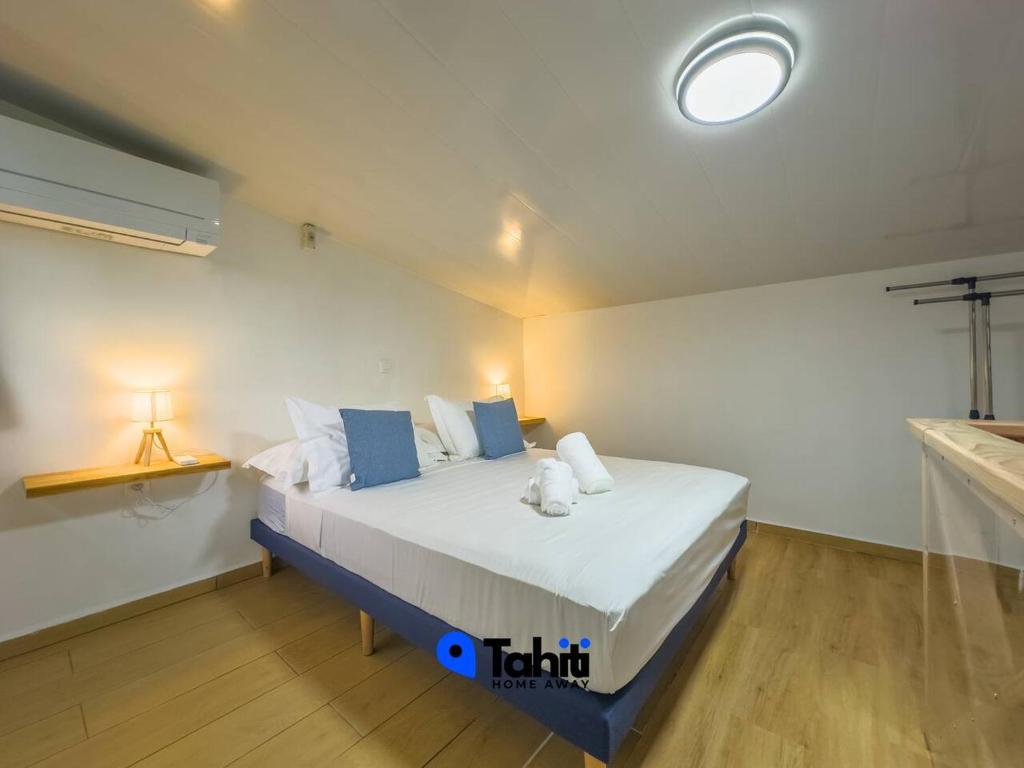 a bedroom with a large bed in a room at Moorea Temae Surf Tiny House in Teavaro