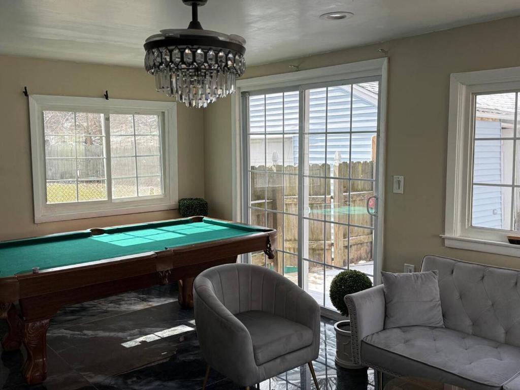 a living room with a pool table and a chandelier at The Slate and Stone House in Buffalo