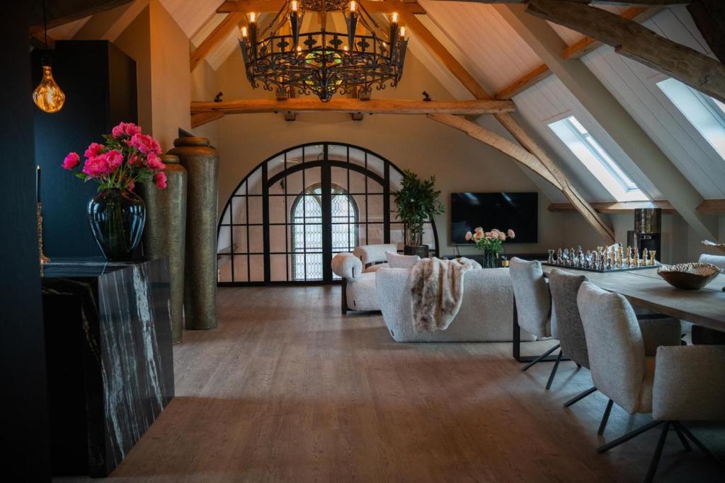 a large living room with a chandelier and a table at Room4 in Maurik