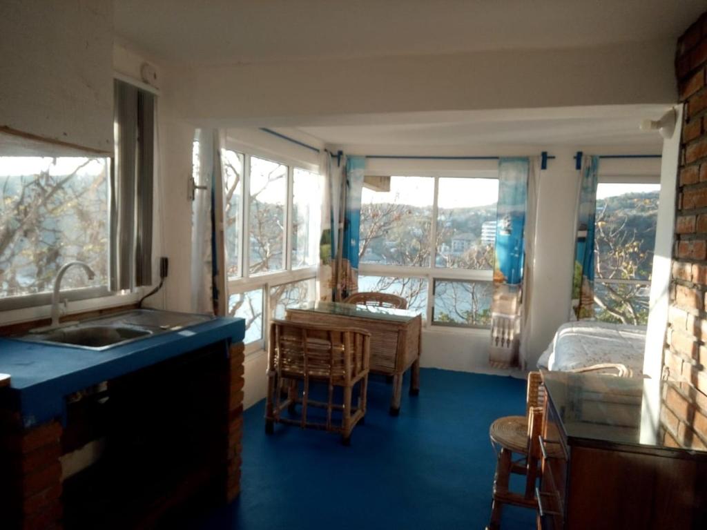 a kitchen with a sink and a room with a bed at The Blue Apartment in Puerto Ángel