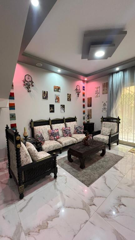 a living room with two couches and a table at Spring house in Qaryat Shākūsh
