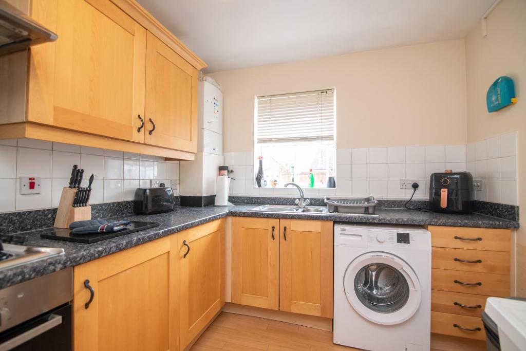 a kitchen with a washing machine and a sink at Fantastic 4 bed house with 3 bathrooms in pleasant location in Great Barr