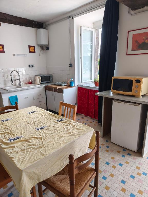 a kitchen with a table with a table cloth on it at Maisonnette de campagne in Val Couesnon