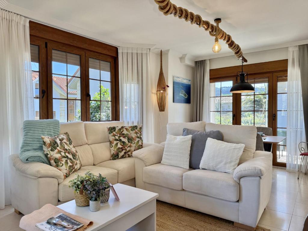 a living room with two white couches and a table at Casa individual - Villa Castillo 7804 in Castillo