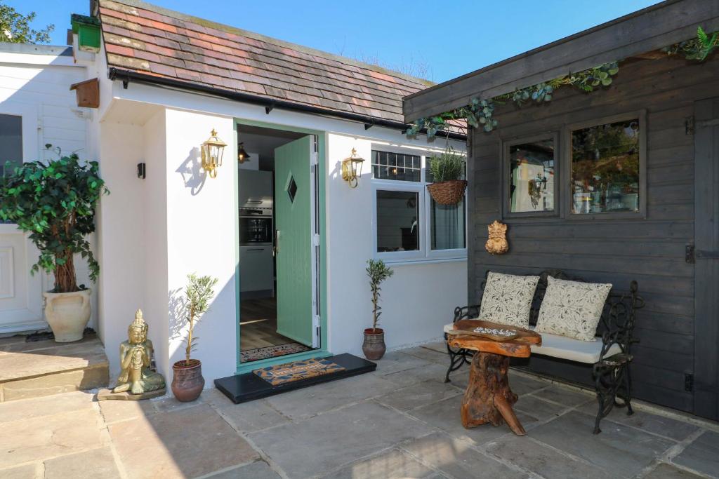 a patio with a bench and a house at Shell Cottage in Bournemouth