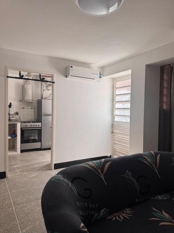a living room with a couch and a kitchen at Cómodo apartamento en el centro de caraca in Caracas
