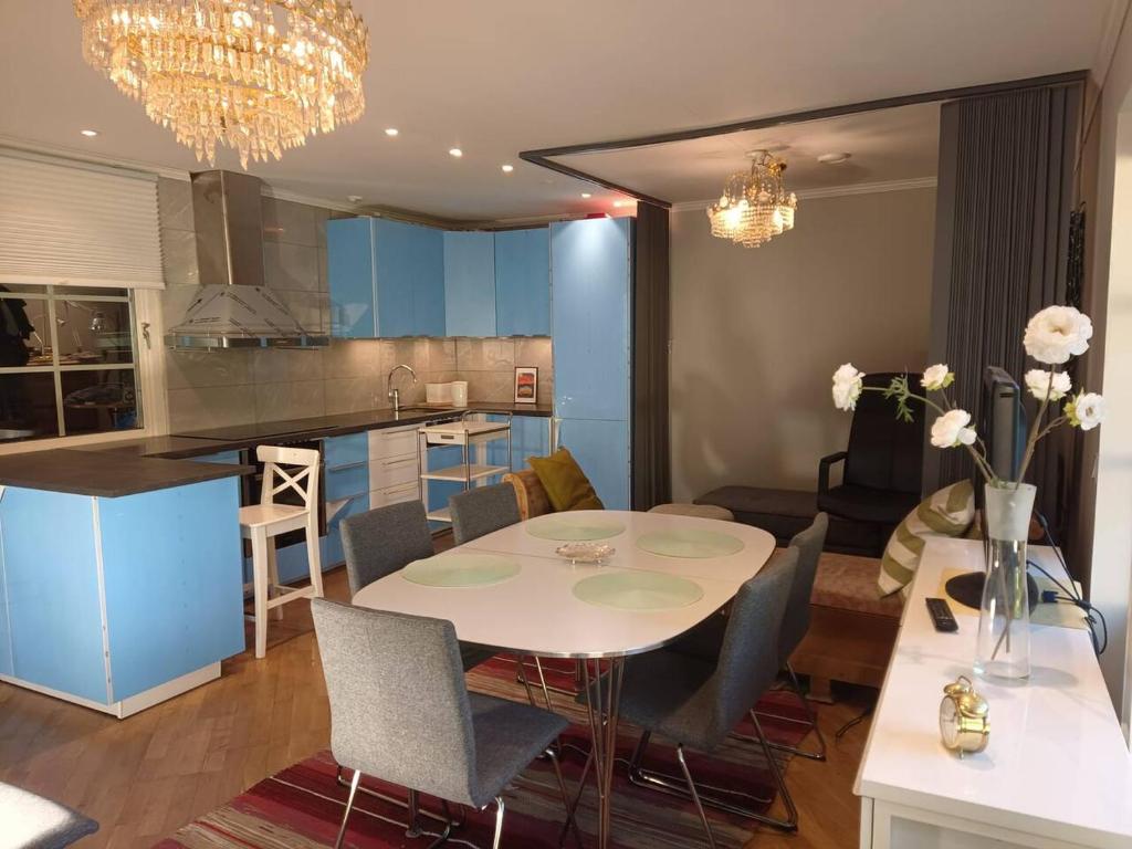 a kitchen and dining room with a white table and chairs at Workers Stay - Temporary House Umeå in Umeå