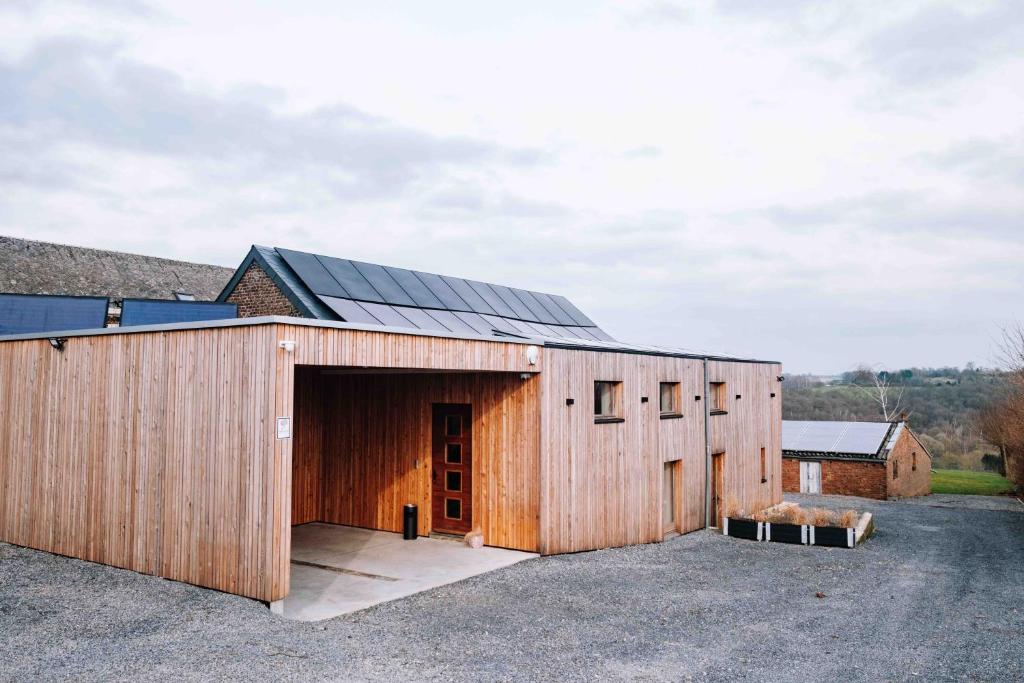 a large wooden building with a large garage at Gîte Grise Pierre in Herve