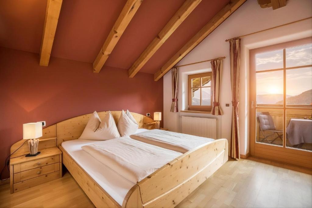 a bedroom with a wooden bed and a window at Oberplunerhof - Fewo Bruneck in Colli in Pusteria