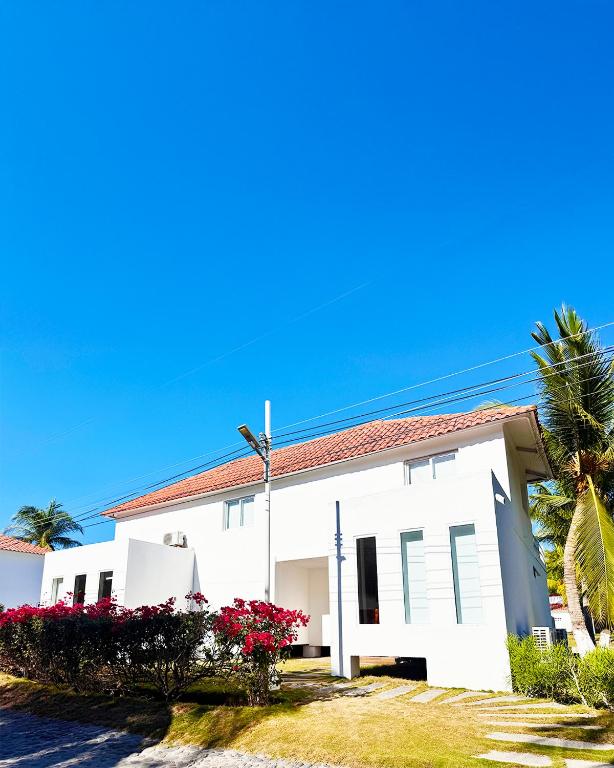 a white house with a palm tree and flowers at Venecia Yatch Club in San Luis La Herradura