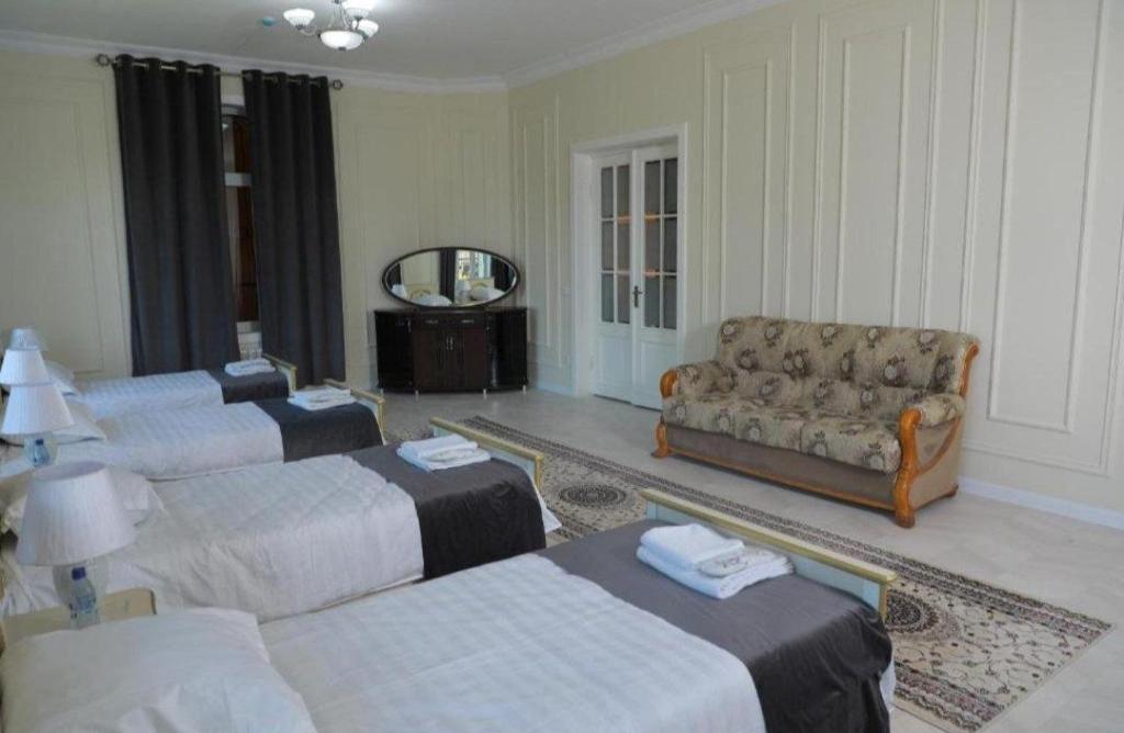 a living room with three beds and a couch at Bodomzor Family Hotel in Salor Bekati