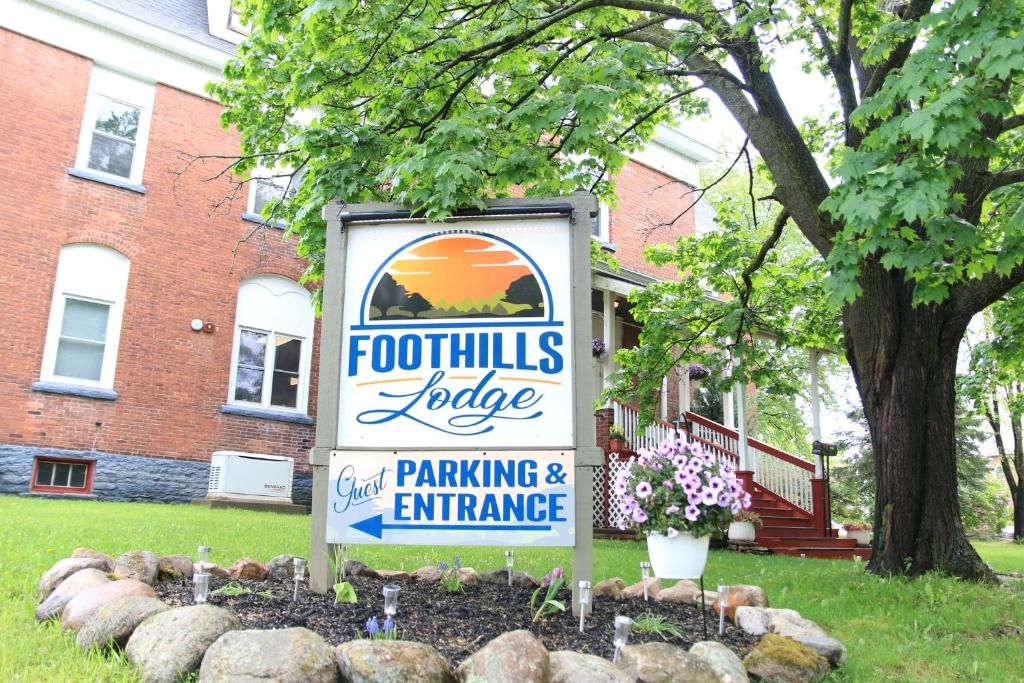 a sign in a yard in front of a building at Foothills Lodge & Cafe in Malone