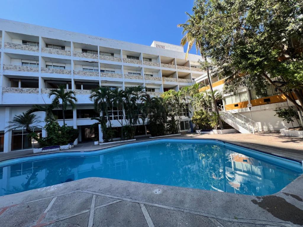 an empty swimming pool in front of a building at Hotel De Cima Beach Club in Mazatlán