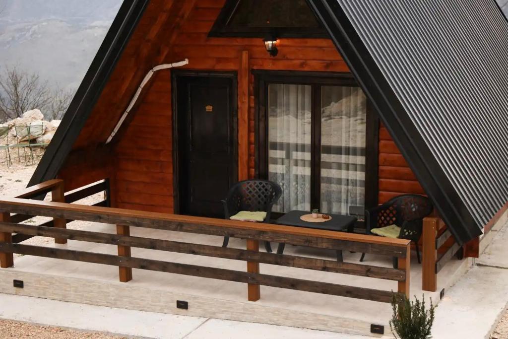a log cabin with two chairs and a window at Podostroška želja in Danilovgrad