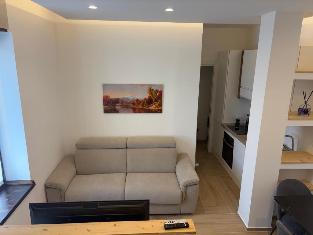 a living room with a couch and a painting on the wall at Bilocale accogliente in centro Aprica in Aprica