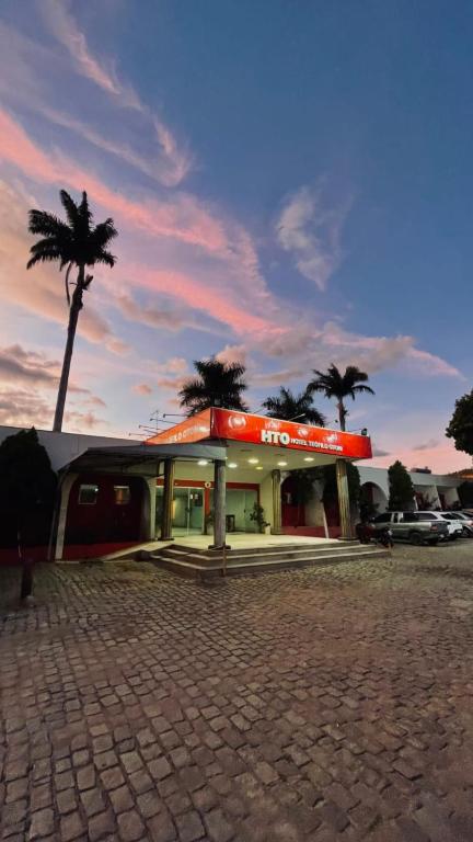 a fast food restaurant with palm trees in the background at Hotel Teofilo Otoni in Teófilo Otoni