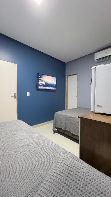 a room with two beds and a tv on a wall at Hotel e Restaurante Santa Isabel in São Raimundo Nonato