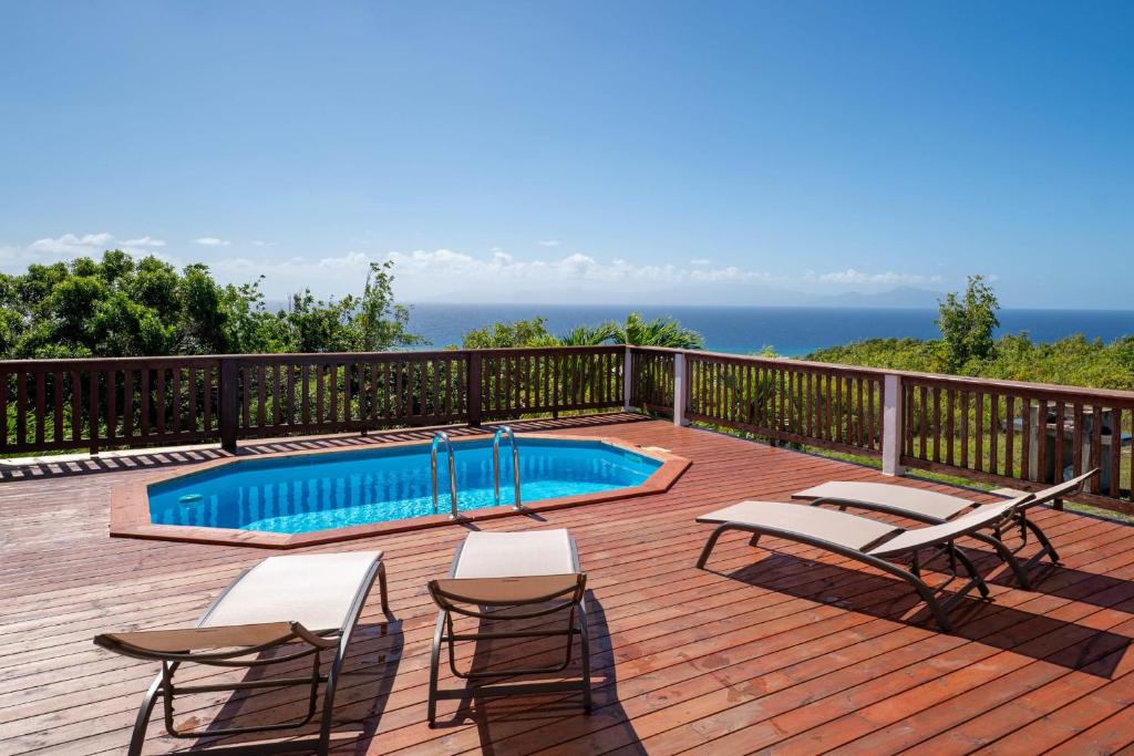 a deck with chairs and a swimming pool at Villa O'Bed in Grand-Bourg