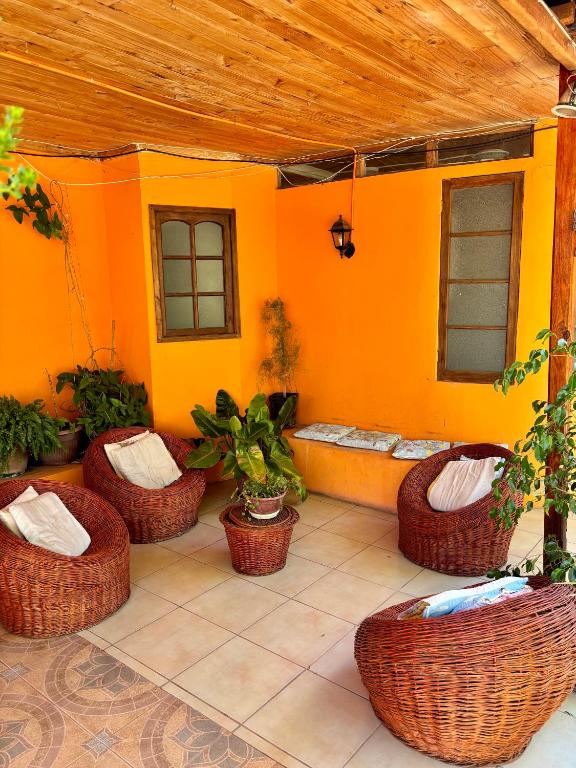 an outdoor patio with wicker chairs and a bench at Alojamiento La Rosa in Combarbalá