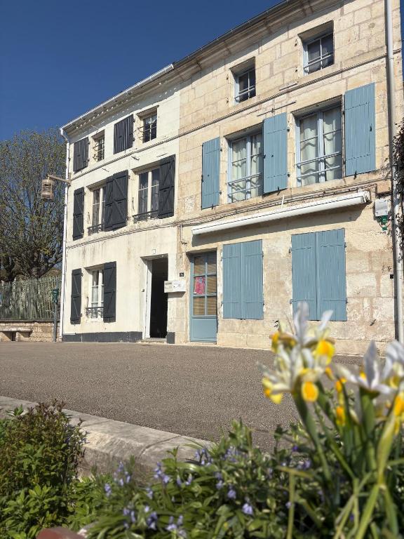 an old brick building with blue doors and windows at Maison bord de sèvre in Coulon
