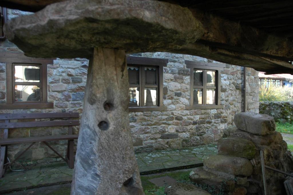 um edifício de pedra com uma árvore em frente em Casa Cecilia em Espinaredo