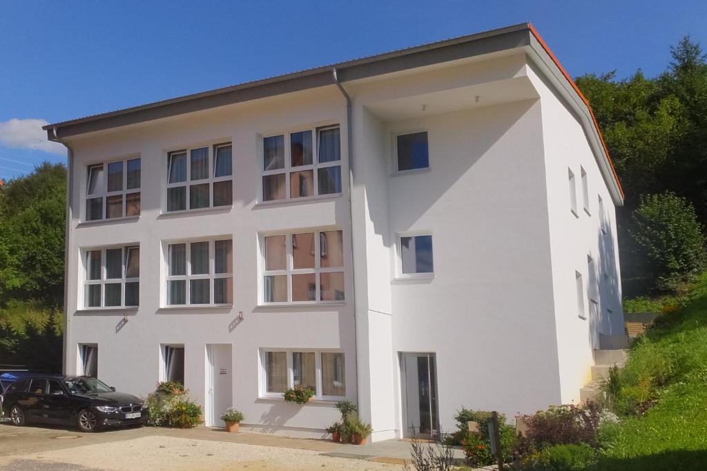 a white building with a car parked in front of it at Gestütsgasthof Marbach in Marbach