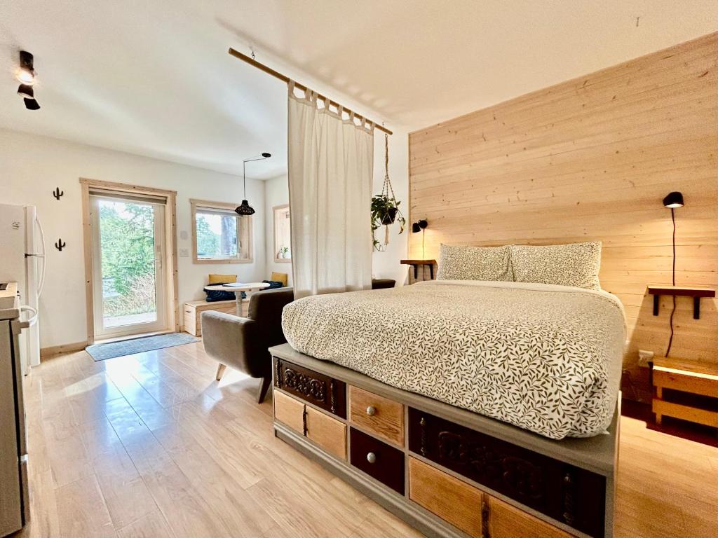 a bedroom with a large bed and a desk at Le Chalet Waterfront Studio Suite, View, Patio, Kitchen in Ucluelet