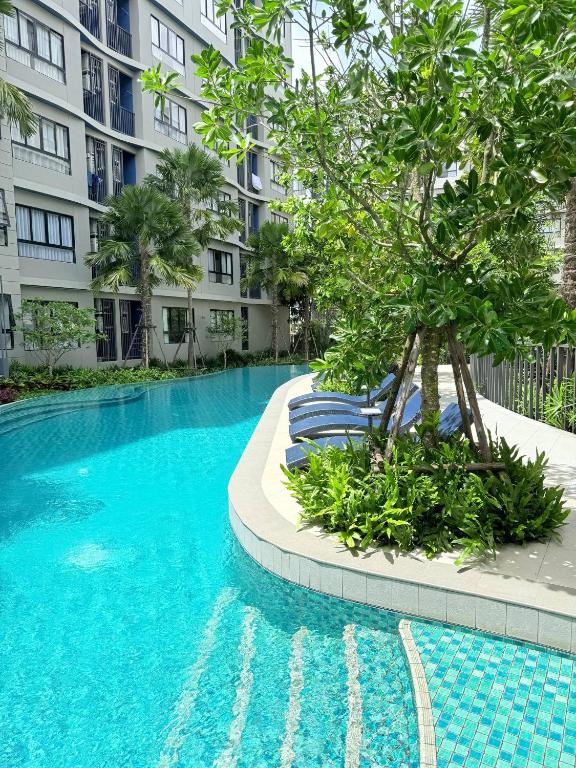 a swimming pool with chairs in front of a building at Dcondo reef artificial pavement Prime location in Kathu